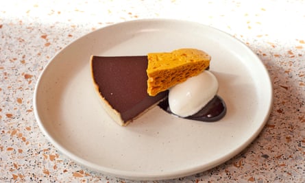 A slice of chocolate tart on a round white plate.