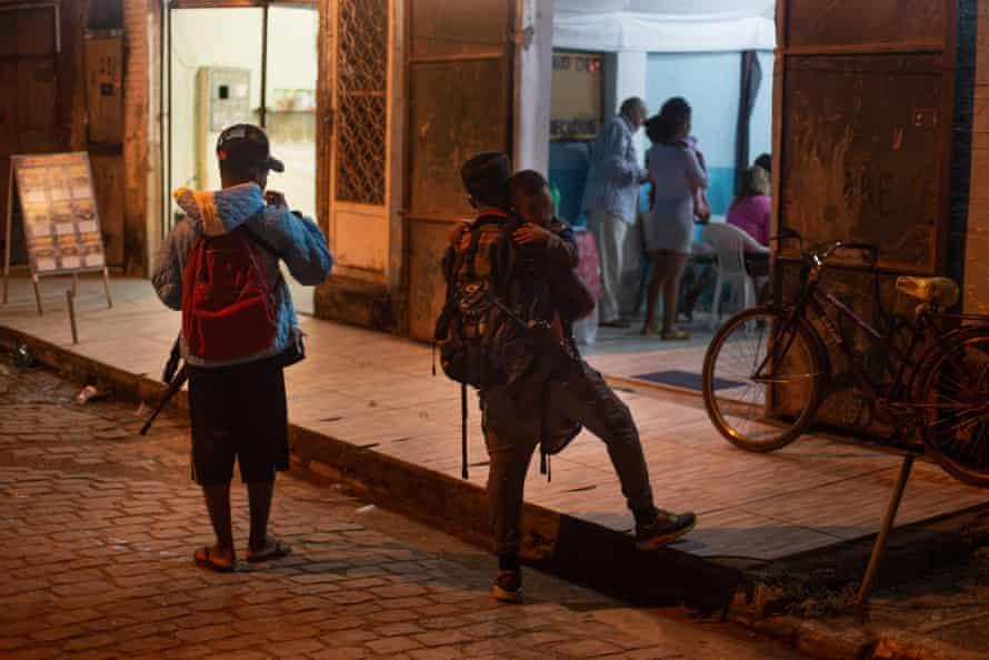 Narcotraficantes armados con rifles escuchan un servicio evangélico afuera de una iglesia en las afueras de Río.