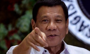 Philippine President Rodrigo Duterte points to photographers during an award ceremony. The journalists’ union has called on him to investigate the killng of a newspaper publisher.