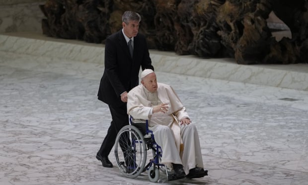 Pope Francis arrives in a wheelchair to attend an audience with nuns and religious superiors in the Vatican.