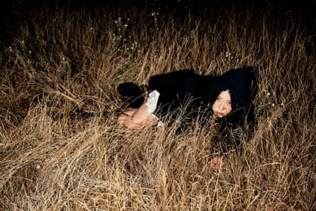 Dis Fig crouches in dry grass lit up by flashlight