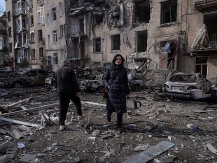 Residents walk through rubble at a site of a Russian airstrike in Druzhkivka in the Donetsk region of Ukraine