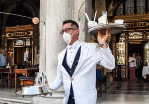 A waiter serves customers on the terrace of the 18th Century Cafe Florian on St. Mark’s Square