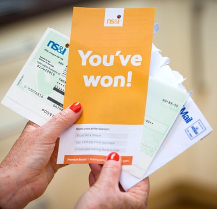 A woman opening a winning premium bonds letter with her winner’s cheque