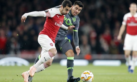 Arsenal’s Henrikh Mkhitaryan and Sporting’s Marcos Acuna challenge for the ball.