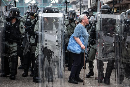 A woman shouts at police officers as they advance towards protesters in Hong Kong in July 2019.