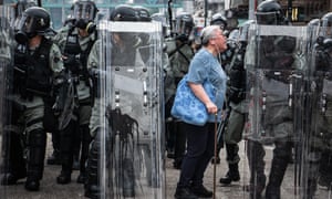 A woman shouts at police officers as they advance towards protesters in the district of Yuen Long during protests in Hong Kong
