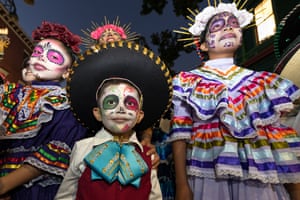 Children wear face makeup and colourful Mexican costumes