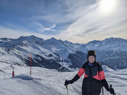 A female skier smiling to camera on ski slopes
