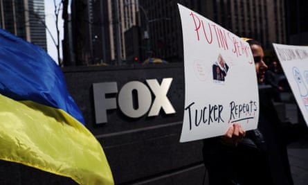 People stand outside the News Corp and Fox News building in New York protesting against Fox News and Tucker Carlson’s coverage of the Russian invasion of the Ukraine.