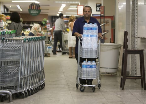 Almir Vicente pushes a cart filled with water. Residents in Rio de Janeiro are alarmed by murky, smelly water coming from their taps. 