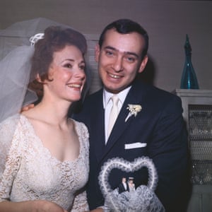 Piper Laurie and Herald Tribune reporter Joseph Morgenstern smile happily from behind their wedding cake after their marriage in Long Beach, California, on 21 January 1962