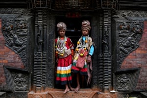 Two dancers in colourful outfits stand in a doorway