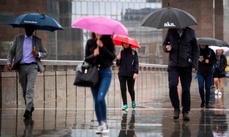 Commuters cross London Bridge in central London as weather warnings.