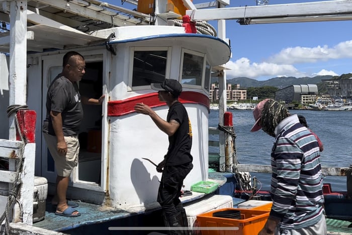 Chou Ting-tai (L), speaking to a crew member while unloading fish products at Badouzi Fishing Port on Thursday in Keelung, Taiwan.