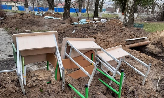 School desks on the ground next to a Russian trench
