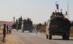 A convoy of Russian military vehicles drives towards the Syrian town of Kobane