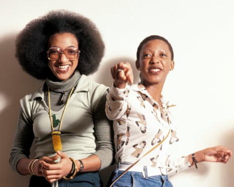 Donna and Althea posing for a portrait, Donna wearing orange tinted sunglasses and Althea pointing at the camera