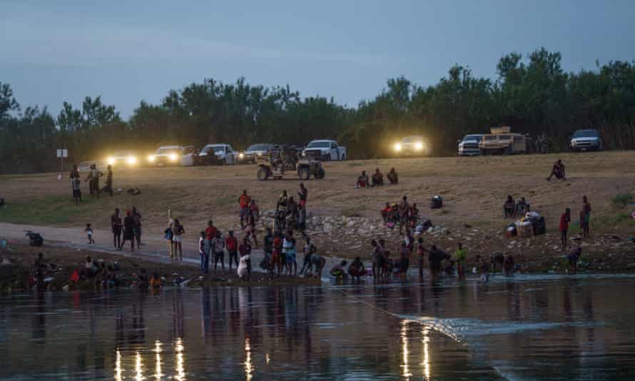 US border patrol, national guard and Texas department of public safety vehicles shine their lights on the Rio Grande migrant crossing point in Del Rio, Texas.