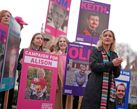 Kim Leadbeater stands in front of campaigners holding Campaign for Dignity in Dying placards