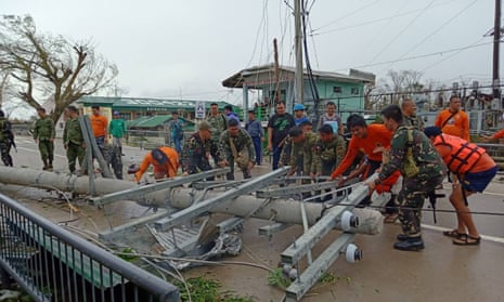 Filipino soldiers help remove downed power lines from the road after Typhoon Mangkhut. 