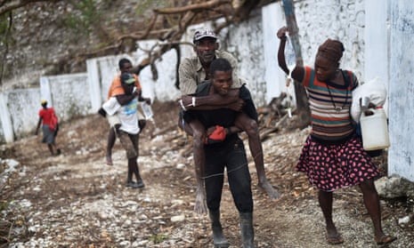 A man with cholera symptoms is carried to a small clinic in Randelle, Haiti, on 19 October 2016
