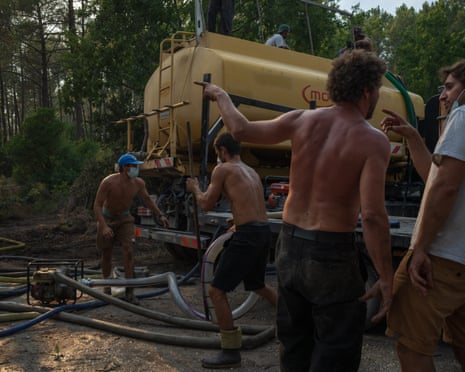 Men working on a firefighting vehicle in woodlands