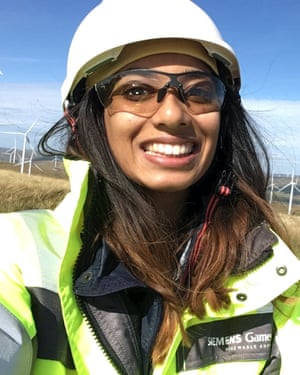 Eishar Bassan in a hard hat and hi-vis jacket, with wind turbines in the background