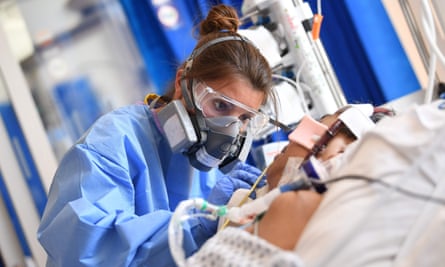 A health worker wears PPE as she cares for a patient in the intensive care unit at Royal Papworth hospital in Cambridge.