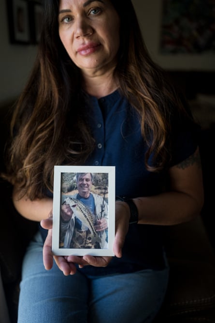 woman holds up framed photo of man holding fish