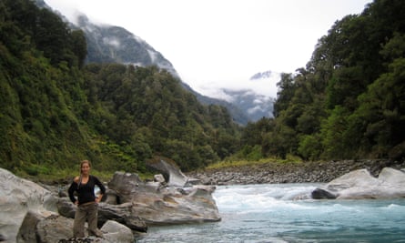Silvia Rothlisberger standing beside a river with trees in the background in New Zealand