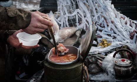 A Ukrainian serviceman serves delivered hot lunch, Ukrainian dish Borscht.
