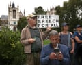 A protester holding a sign saying 'Free speech for all'