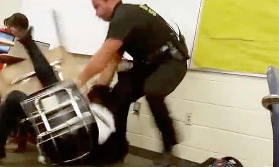 In this Monday, Oct, 26, 2015 photo made from video taken by a Spring Valley High School student, Senior Deputy Ben Fields tries to forcibly remove a student who refused to leave her high school math class, in Columbia South Carolina.