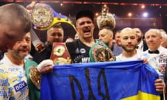 Oleksandr Usyk holds a Ukrainian flag as he celebrates with the undisputed heavyweight title belt following victory over Tyson Fury