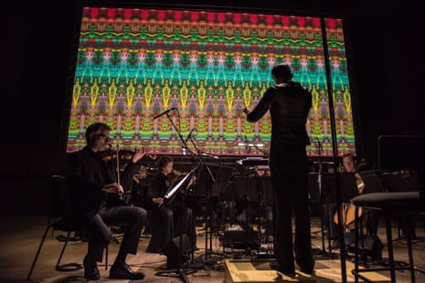 the London Sinfonietta, conducted by Manoj Kamps, perform Steve Reich’s Reich/Richter beneath the film Moving Picture (946-3) by Gerhard Richter and Corinna Belz at the Royal Festival Hall.