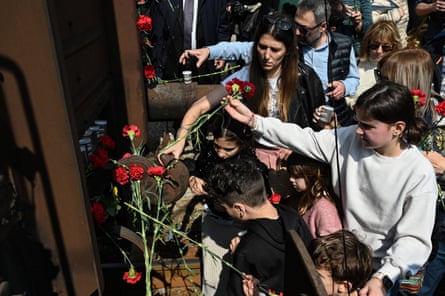 People place flowers at the old railway station in Thessaloniki in March, during a commemoration of the departure of the first train to Auschwitz concentration camp in 1943.