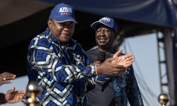 Prezydent Kenii Uhuru Kenyatta (z lewej) bije brawo, tańcząc do popularnej piosenki wyborczej na podium obok swojego byłego przeciwnika politycznego, Raila Odinga, z prawej.