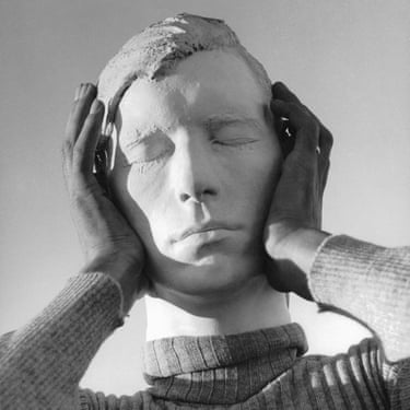 Two hands gently cradle a sculpted plaster head with closed eyes