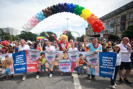 People dressed in colourful clothes marching at the Hamburg Pride event.