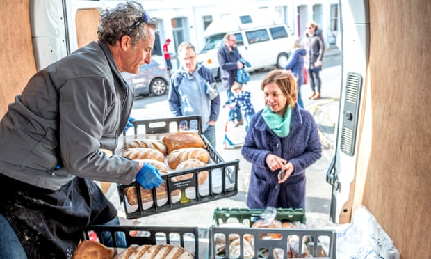 A baker who is no longer able to supply restaurants sells bread to Brighton residents yesterday from the back of his van.