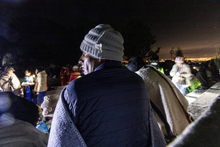 Wearing woolly hats and with blankets around them, residents gather in the main square of in Chupuro following the earthquake which struck on Saturday evening