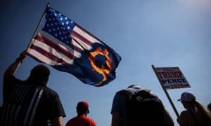 A supporter of President Donald Trump holds an U.S. flag with a reference to QAnon