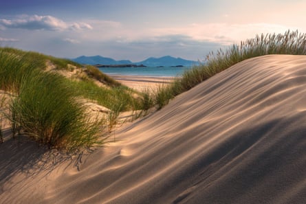 A view from the dunes at Newborough beach, with Llanddwyn Island and the Lleyn Peninsula in the distance2JWF998 Sand dunes and marram grass at Newborough , Anglesey, North Wales. Llanddwyn Island and the Lleyn Peninsula in distance