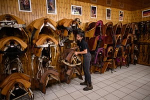 A groom at the Cadre Noir de Saumur, part of the French military riding academy, prepares saddles for a morning show
