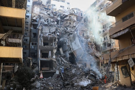 A tall destroyed building in a narrow street.