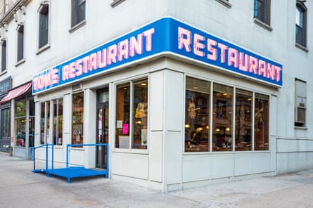 neon sign on a building reads ‘Tom’s Restaurant’