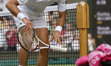 Novak Djokovic with his smashed racket after breaking it on a net post