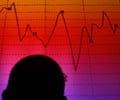 A man is silhouetted in an electronic board showing the FTSE MIB Index.