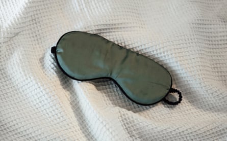 a green eye mask for sleeping shown on a bed